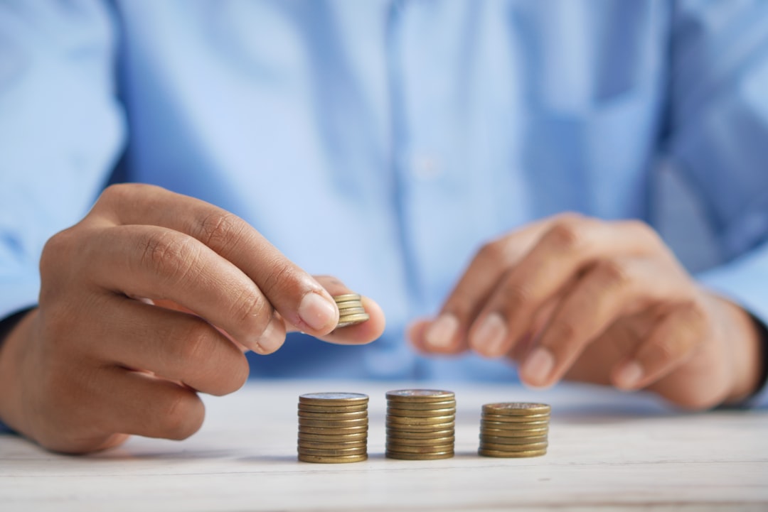 a-person-stacking-coins-on-top-of-a-table-jpqyfk7gb4w